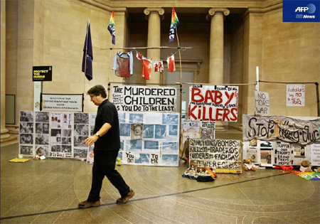 2007年1月15日、ロンドンのテート・ブリテン内に展示されたマーク・ウォリンガー氏の作品『State Britain』とその前を歩く同氏。（AFPBB News）